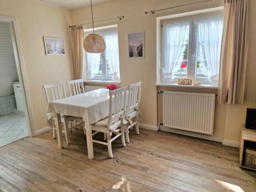 Un comedor con una mesa y sillas blancas. en Küstenglück Sylt D1, en Westerland