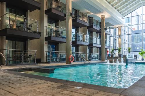 an indoor swimming pool in a building with balconies at Hôtel Universel, Centre de congrès Rivière-du-Loup in Rivière-du-Loup