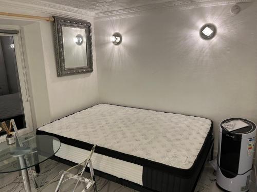 une petite chambre avec un lit et un miroir dans l'établissement Studio à 2 minutes de lafayette, à Paris
