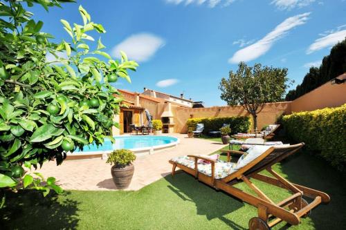 une cour avec une piscine et une chaise longue dans l'établissement Proche Château de Salses, Maison avec piscine, à Salses-le-Chateau
