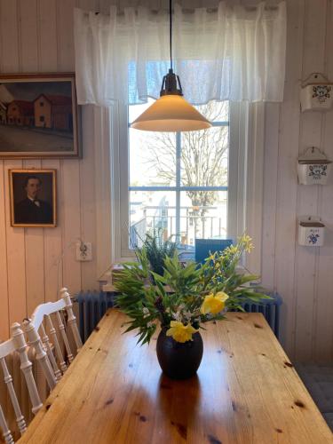 a dining room table with a vase of flowers on it at Konstnärsvåningen i Villa Sol in Borgholm