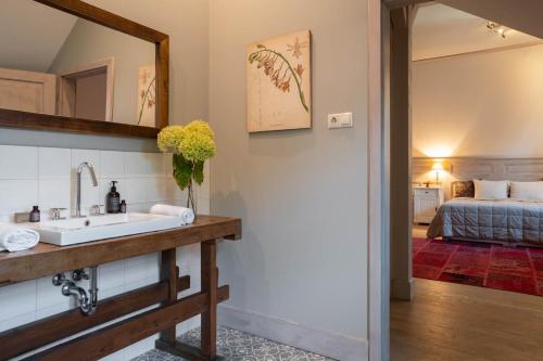 a bathroom with a sink and a bedroom at Botanica in Dánszentmiklós