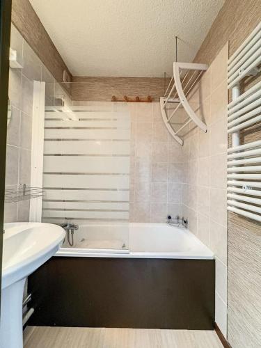 une salle de bain avec une baignoire et un lavabo dans l'établissement Studio Samoëns 1600, à Samoëns