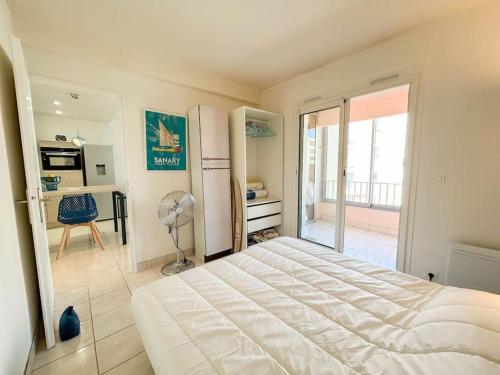 une chambre avec un grand lit blanc et un balcon dans l'établissement T3 avec garage proche de la mer, à Sanary-sur-Mer