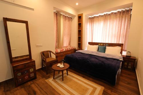 a bedroom with a bed and a mirror and a chair at Vista Valley Stay, Luxury 3 BHK Villa Kangra, Dharamshala in Dharamshala