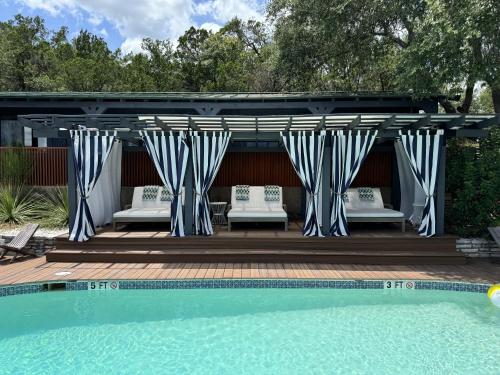 a blue and white gazebo with benches next to a pool at The Bygone in Wimberley