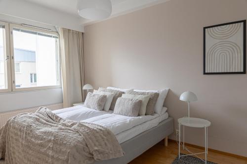 Un dormitorio blanco con una cama y una ventana. en Riverside Suites by BookLapland, en Rovaniemi