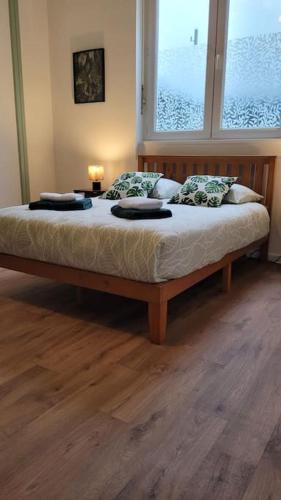 a bedroom with a bed with two pillows and a window at Le Botanique à 250m de la gare,15 min de Lille in Tourcoing