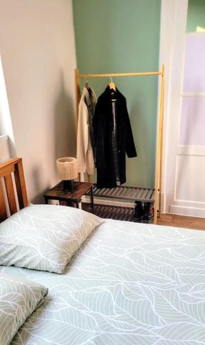 a bedroom with a bed and a rack of clothes at Le Botanique à 250m de la gare,15 min de Lille in Tourcoing