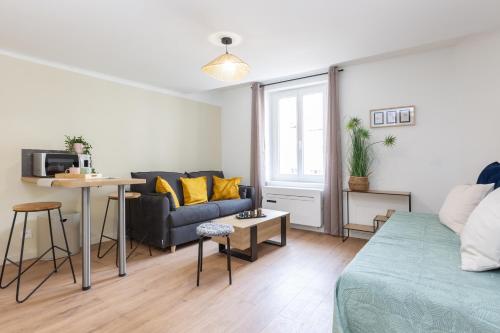 un salon avec un canapé et une table dans l'établissement Escapade au port, Studio rénové, climatisé, à La Seyne-sur-Mer