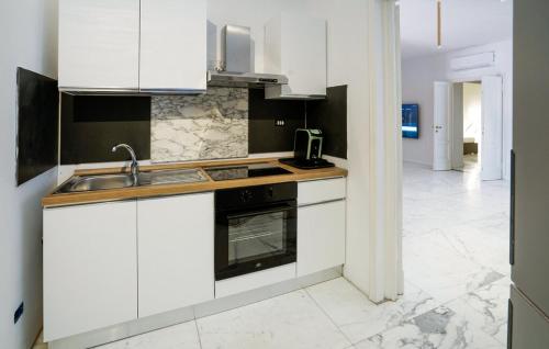 a kitchen with white cabinets and a sink and a stove at greve center apartments in Greve in Chianti