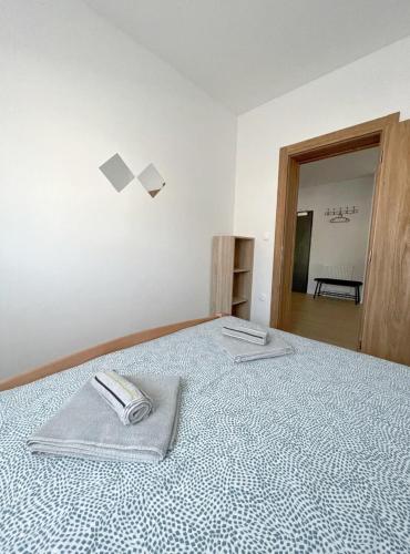 a bedroom with a bed with two towels on it at Apartman Danijela in Popovača