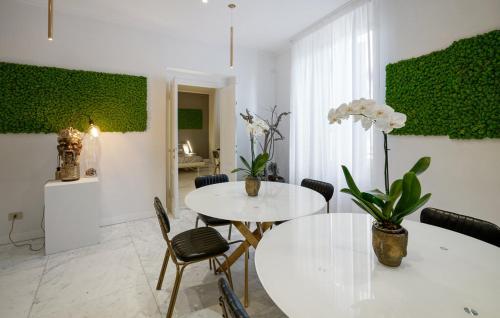 a dining room with two white tables and chairs at greve center apartments in Greve in Chianti