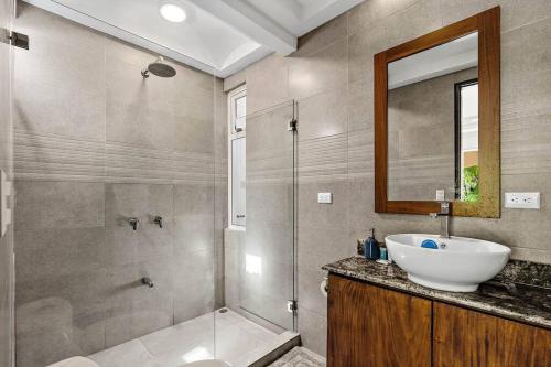 塔马林多Gav10 Modern Pool Side Condo in Quiet Area of Tam的配有水槽、淋浴和镜子的浴室