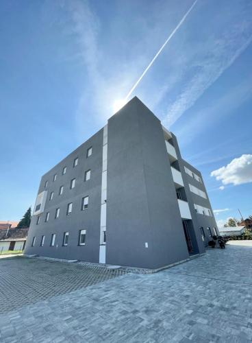 a large building with the sun behind it at Apartman Danijela in Popovača