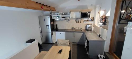 a small kitchen with white appliances and a table at Appartement Terrasse sur le port in La Seyne-sur-Mer