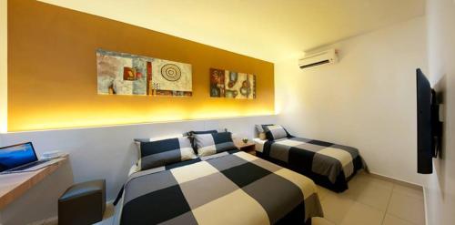 a hotel room with two beds and a tv at Rivero Boutique Hotel Melaka in Melaka