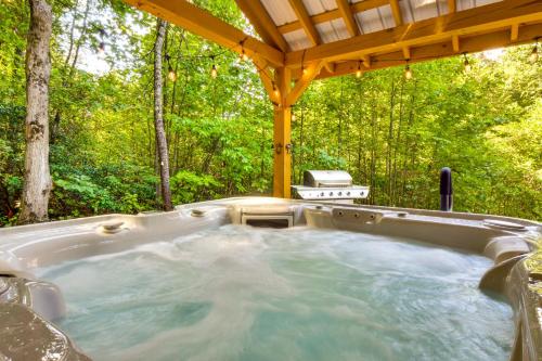 a hot tub in a gazebo in the woods at Painted Skies Upscale Getaway By Lake Burton! in Tiger