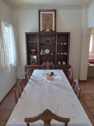 a dining room with a table and a cabinet at Fazenda Morro Alto Alegre in Jacutinga