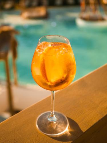 a wine glass sitting on a table next to a pool at Alia Suites and Spa in Haraki