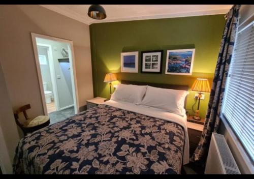 a bedroom with a bed and a green wall at Puddledock - luxury lodge - Romney Marsh, Kent in Brookland