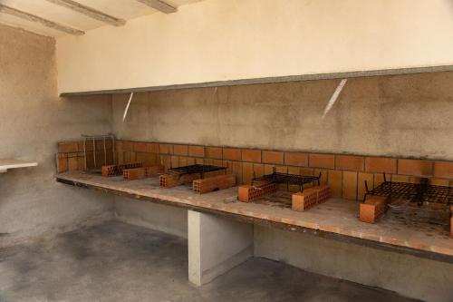 a room with a counter with bricks on the wall at Camping Ciudad del Ciclismo in Cervera del Maestre
