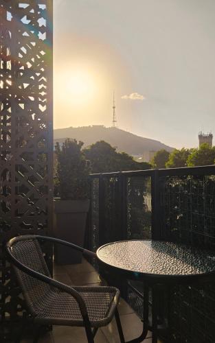 a table and chairs on a balcony with a view at Griffin Hotel in Tbilisi City