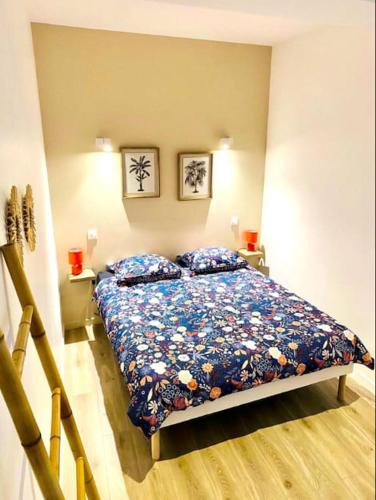 une chambre avec un lit et deux tableaux au mur dans l'établissement Le Tarasconnais Tarascon Arles Nîmes, à Tarascon