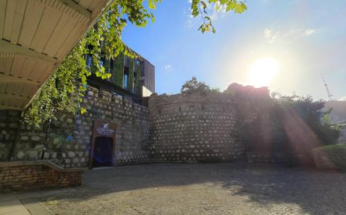a brick wall with the sun shining behind it at Griffin Hotel in Tbilisi City
