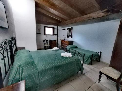 a bedroom with two green beds and a chair at Holiday Residence in Casamassima
