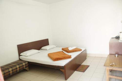 a bed in a room with two towels on it at Subhash Hotel in Prayagraj