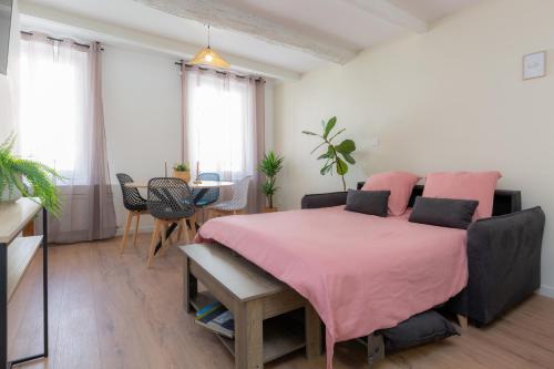 - une chambre avec un lit rose et une couverture rose dans l'établissement Evasion au Port, T2 climatisé rénové, à La Seyne-sur-Mer