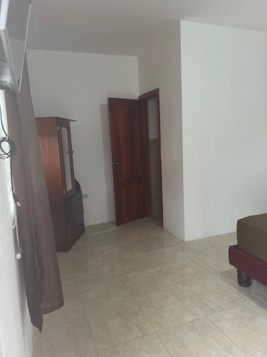 a living room with two wooden doors and a tiled floor at La esquina de flipper in Manta