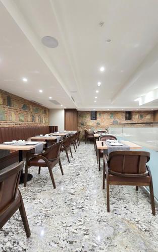 a dining room with wooden tables and chairs at Griffin Hotel in Tbilisi City