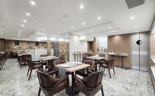 a restaurant with tables and chairs and a kitchen at Griffin Hotel in Tbilisi City