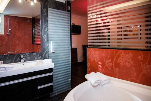 a bathroom with a tub and a sink and a toilet at Hotel Maroussi in Athens