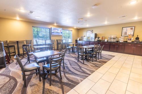 a restaurant with tables and chairs and a bar at Cobblestone Inn & Suites - Winters in Winters