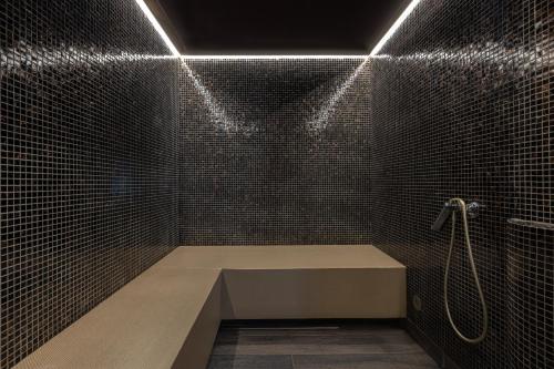 a bathroom with a shower with a bench in it at Villa Buki Pokoje & SPA in Jastrzębia Góra