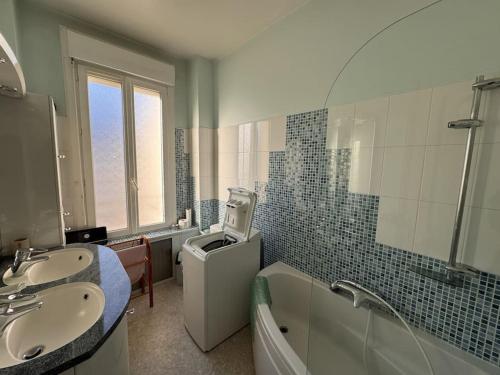 une salle de bain avec deux lavabos et une baignoire et des toilettes dans l'établissement Le Coquelicot - Centre - 8 Pers - Parking, au Mans