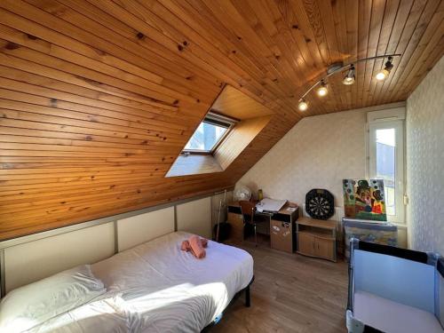 une chambre avec un lit et un plafond en bois dans l'établissement Le Coquelicot - Centre - 8 Pers - Parking, au Mans