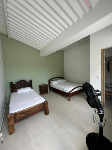 a room with two beds and a fan in it at Finca Villa Sofía Campestre con piscina in Anapoima