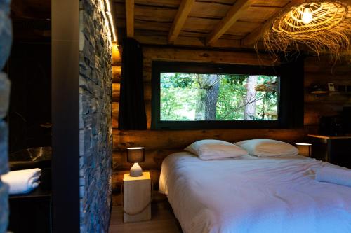 Postel nebo postele na pokoji v ubytování La Cabane de l'Étang du Domaine de la Forestière