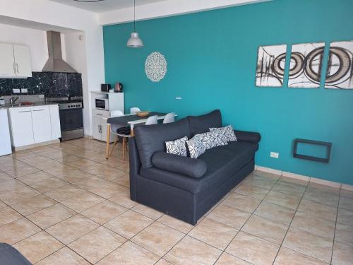 a living room with a couch and a blue wall at Hermoso departamento en complejo residencial in Tigre