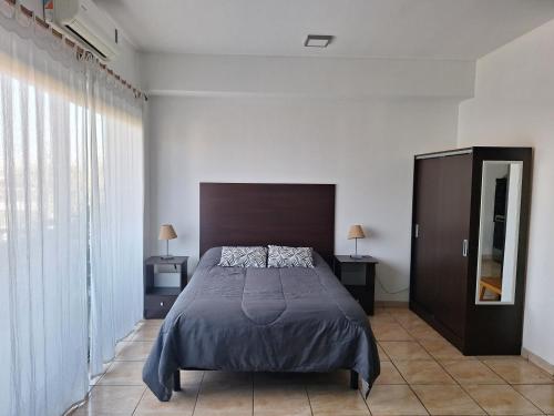 a bedroom with a bed and a large window at Hermoso departamento en complejo residencial in Tigre