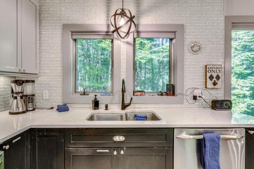 Una cocina con fregadero y dos ventanas. en Vermont Mountain Retreat The Antler House, en Plymouth
