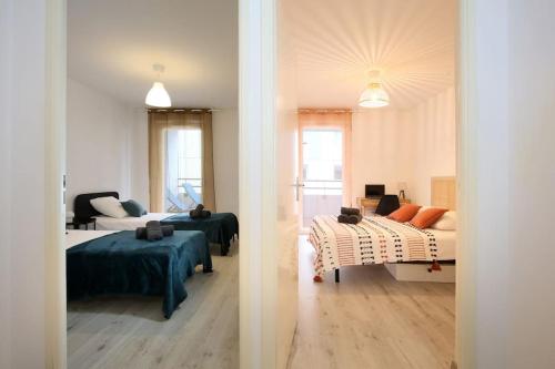 - deux vues sur une chambre avec deux lits et un canapé dans l'établissement NEW-Le Patio St Cyprien - Parking - Terrasse - Netflix, à Toulouse