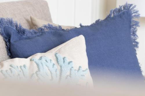 a pile of blue pillows on a bed at Strandschönheit in Wangerooge