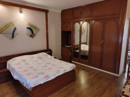 a bedroom with a bed and a wooden cabinet at Welcoming 3-Bedroom Villa in Bengaluru in Bengaluru