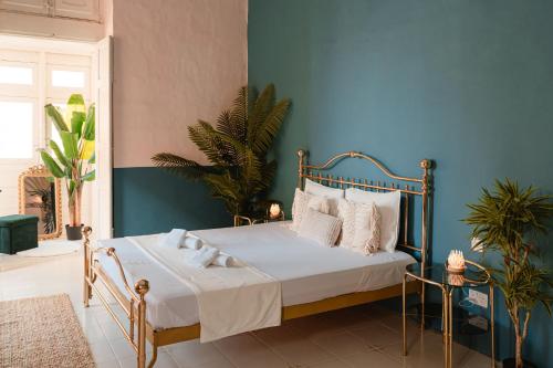 a bedroom with a bed with a blue wall at Senglea Jungle Palazzo in Senglea