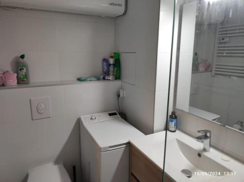 une salle de bain blanche avec un lavabo et une douche dans l'établissement Studio cabine tout équipé, au Lavandou